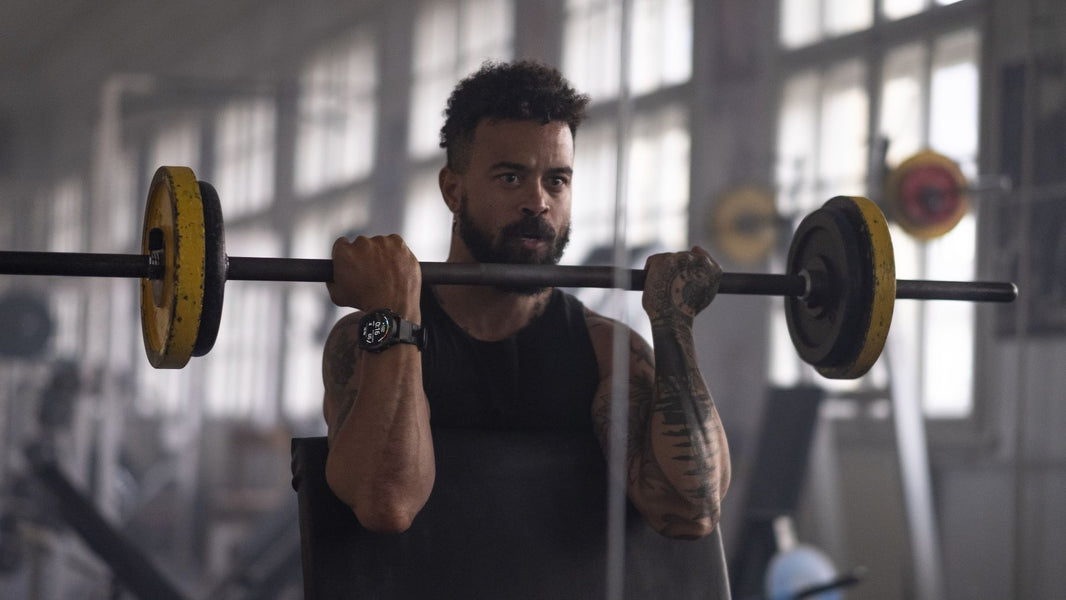 Man lifting a straight bar wearing the garmin fenix 8 multisport gps smartwatch