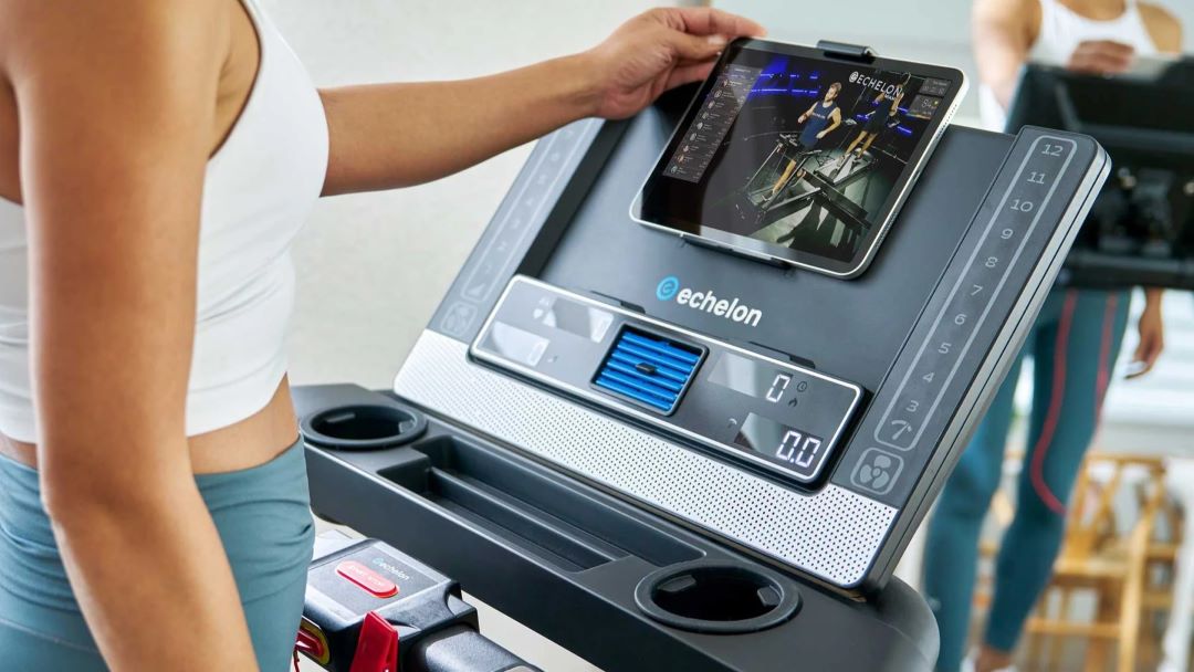 Woman using ZiahCare's Echelon Treadmill screen controls