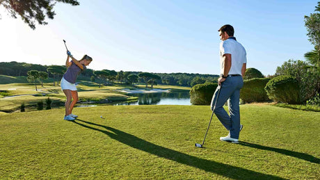 Man and woman golfing wearing Garmin Watches
