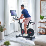 man using Echelon EX-5s Smart Connect Bike in living room 