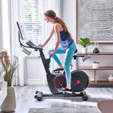 Woman using Echelon EX-5s Smart Connect Bike in living room 