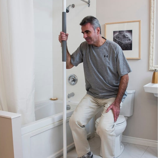 Middle aged man using SuperPole Support System while getting up from toiletHealthCraft SuperPole Support System