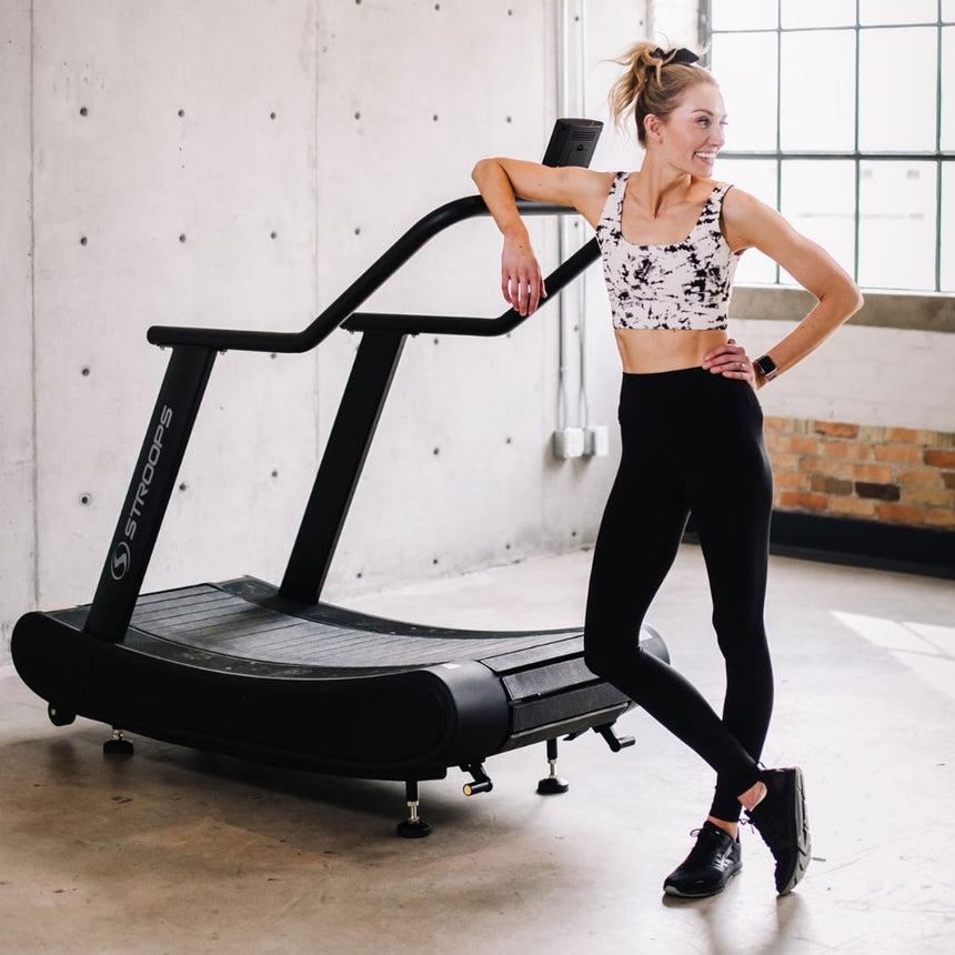 woman standing next to Opticurve Curved Treadmill 