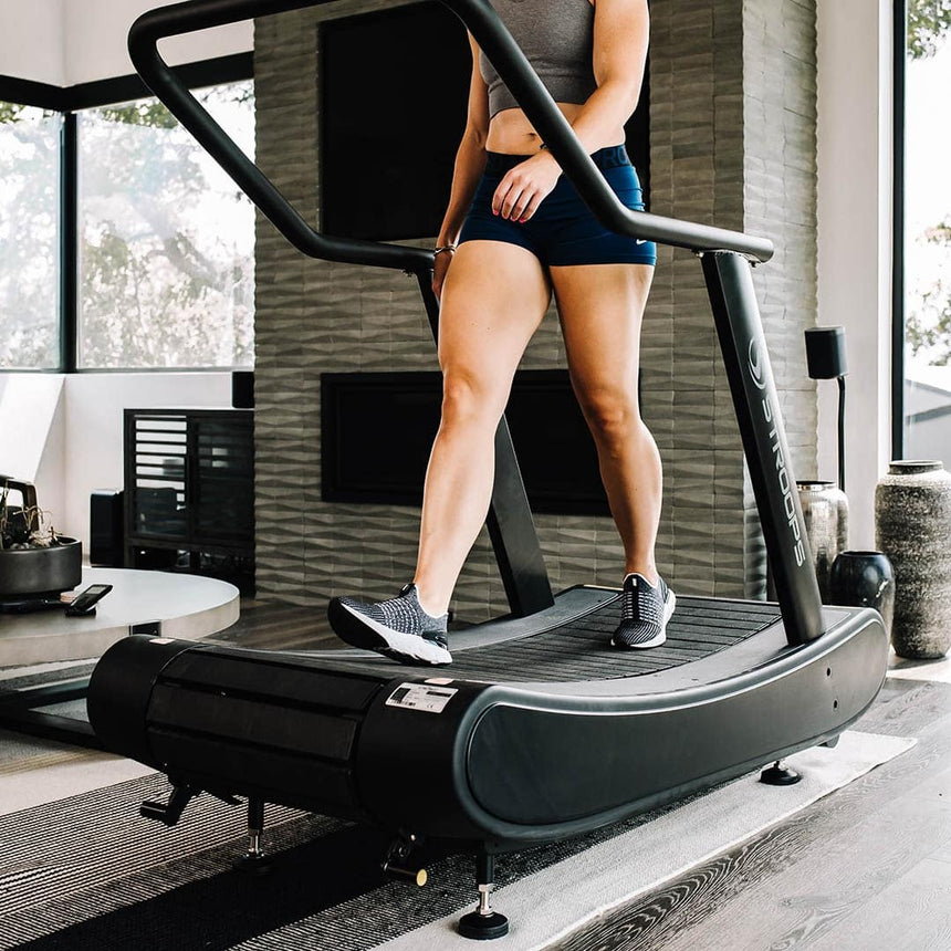 Woman using Opticurve Curved Treadmill in home