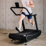 man using Opticurve Curved Treadmill in home