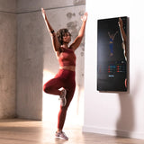 Woman using Echelon Reflect 50" Smart Fitness Mirror in home 