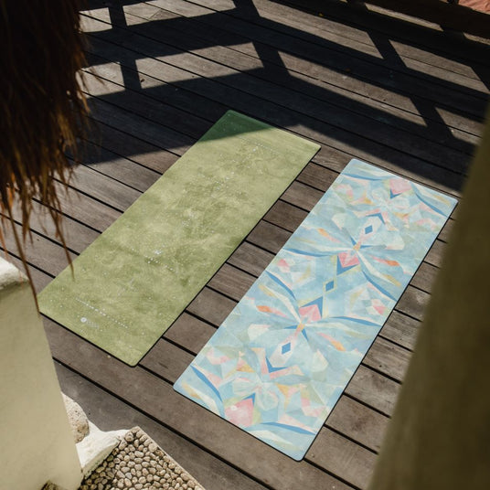 two yoga design lab combo mats laying side by side outdoors on deck